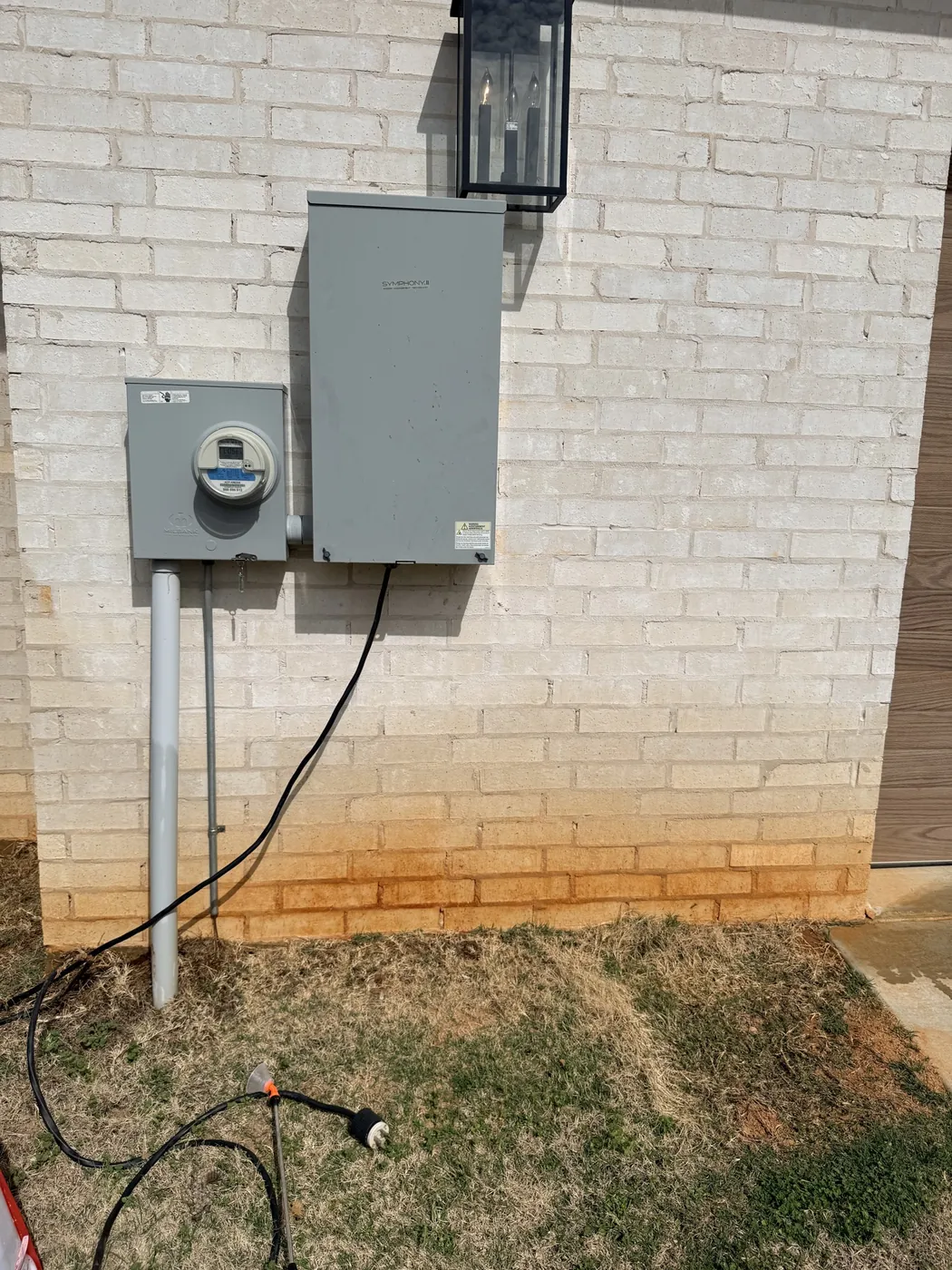 Before: rust-stained white brick wall below an electric meter, restored by B&H