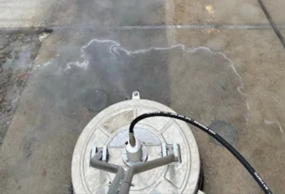 Surface cleaner mid-pass showing clean versus dirty concrete